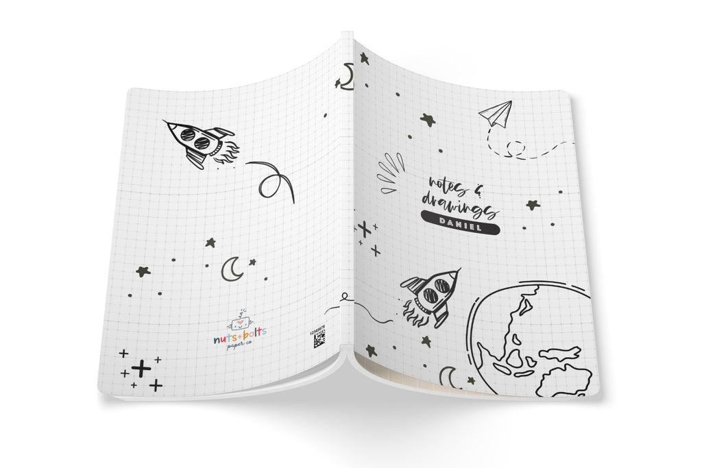 notes & drawings soft cover notebook laying open on flat surface