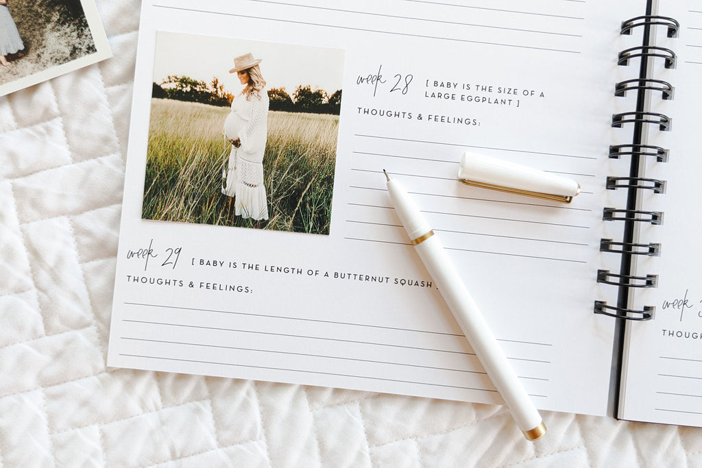 pregnancy journal book to track pregnancy week by week with pictures of baby and belly and journaling space sitting on white quilt with pregnant woman photo